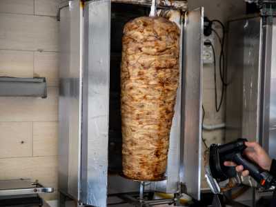 Dietro al bancone regna poi sovrano lo spiedo verticale che infilza il cilindro di carne halāl, prodotta conformemente alle ferree norme religiose musulmane